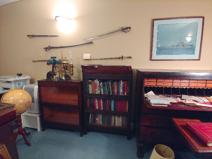 Museum display of swords, books and pictures